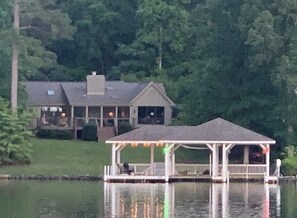 A lakeside property with a gazebo, a house, and a dock.