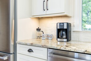 A kitchen with a coffee maker, a milk frother, and a coffee pot on the counter. - Lakefront 3-bedroom house on Poe Creek at Lake Gaston. Bring your boat! (Littleton)