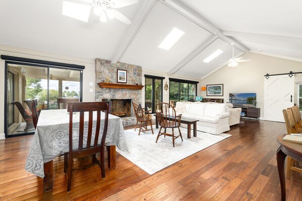 A spacious living area with a fireplace, dining table, and seating.
