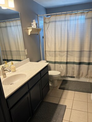 Ein Badezimmer mit Waschbecken, Toilette und Duschvorhang.