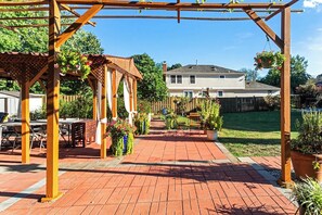 A patio with a pergola, outdoor seating, and potted plants. - Cozy 2-bedroom house in peaceful Woodbridge with AC (Woodbridge)