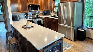 Une cuisine moderne avec des meubles en bois, des appareils électroménagers en acier inoxydable et un grand îlot central.