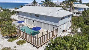 Ein Strandgrundstück mit zwei Etagen, inklusive Schwimmbad, Terrasse und Meerblick.
