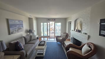 A living room with a sofa, armchair, coffee table, and a fireplace.