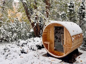 A wooden cabin with a circular shape, a glass door, and a snow-covered roof. - Whimsy Wild: Walk to Downtown Saugatuck, Sauna, Hot Tub, Screen Porch, Fire Pit (Saugatuck)