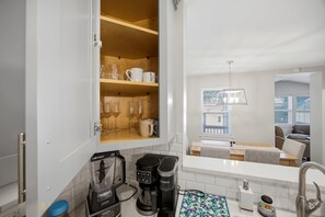 Uma cozinha moderna com cafeteira, chaleira e máquina de café no balcão.