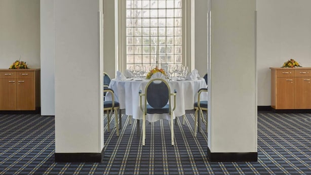A conference room with a table set for a meeting, a large window, and a carpeted floor. - 1 Person Holiday Park Home in Hurth (Huerth)