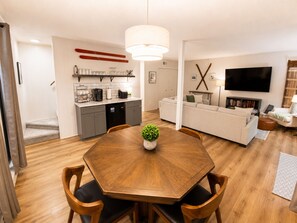 Ein zeitgemäßer Wohnraum mit Essbereich, Küche und Wohnzimmer mit Fernseher.