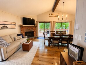 Una sala de estar con chimenea, un sofá, una mesa de centro y un televisor.