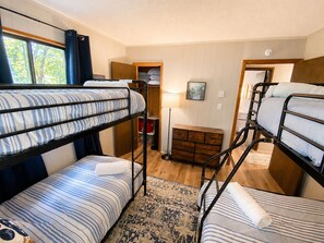 A bunk bed room with a wooden dresser and a lamp. - Lake Access, Game Room, Close to Skiing, Sleeps 10 (Albrightsville)