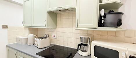 A kitchen with a stove, microwave, toaster, and coffee maker.