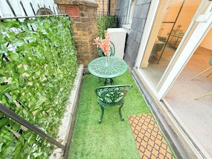 A small outdoor area with a green artificial turf, a round table, and a chair. - Prime City of London Accomodation in St Paul’s, Bank, Liverpool Street for (London)