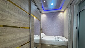 A bedroom with a bed, a mirror, and a ceiling light. - Modern Apartment with Wi-Fi and Air Conditioning, Near the Beach and the Medina (Tanger)