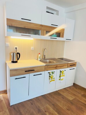 A modern kitchen with white cabinets, a wooden countertop, a stainless steel sink, and a kettle. - Serene 1-bedroom apartment with 2 AC in sunny Sunny Beach, 5 min to the beach (Sunny Beach)