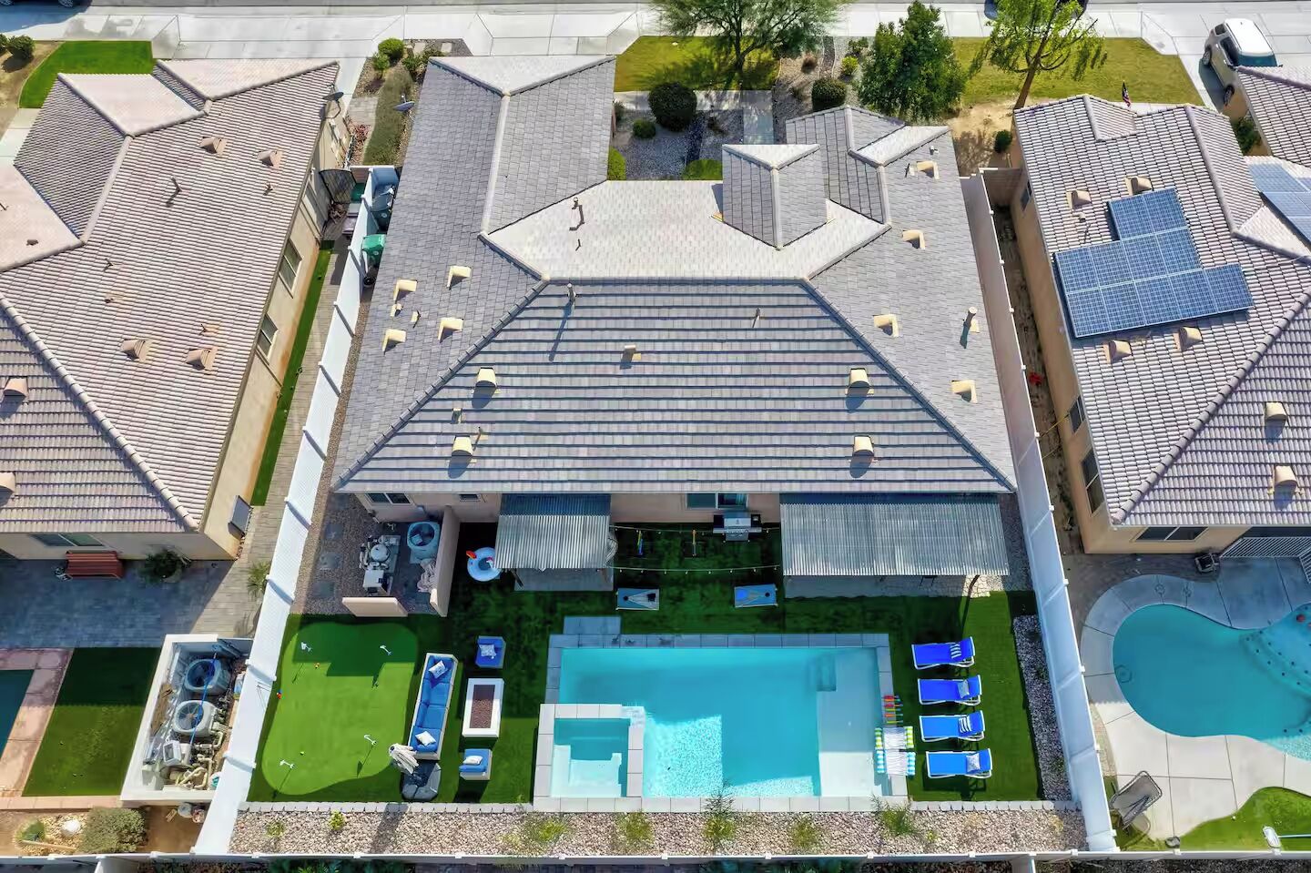 A residential building with a rooftop pool, multiple balconies, and a well-maintained lawn.