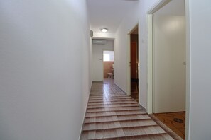 A narrow hallway with a tiled floor, a door on the right, and a bathroom visible through an open door at the end. - Apartment 2450/264997 (Istria - Fažana), 300m from the beach (Fažana)