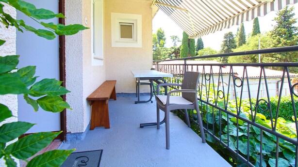 A balcony with a table and chairs, a bench, and a view of greenery. - Apartment 2450/264998 (Istria - Fažana), 300m from the beach (Fažana)