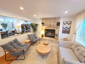 A modern living room with a fireplace, a large mirror, and a sofa. - Private Nature Retreat | King Suite, 2.5 Baths | Near Navy Base & Six Flags (Waukegan)