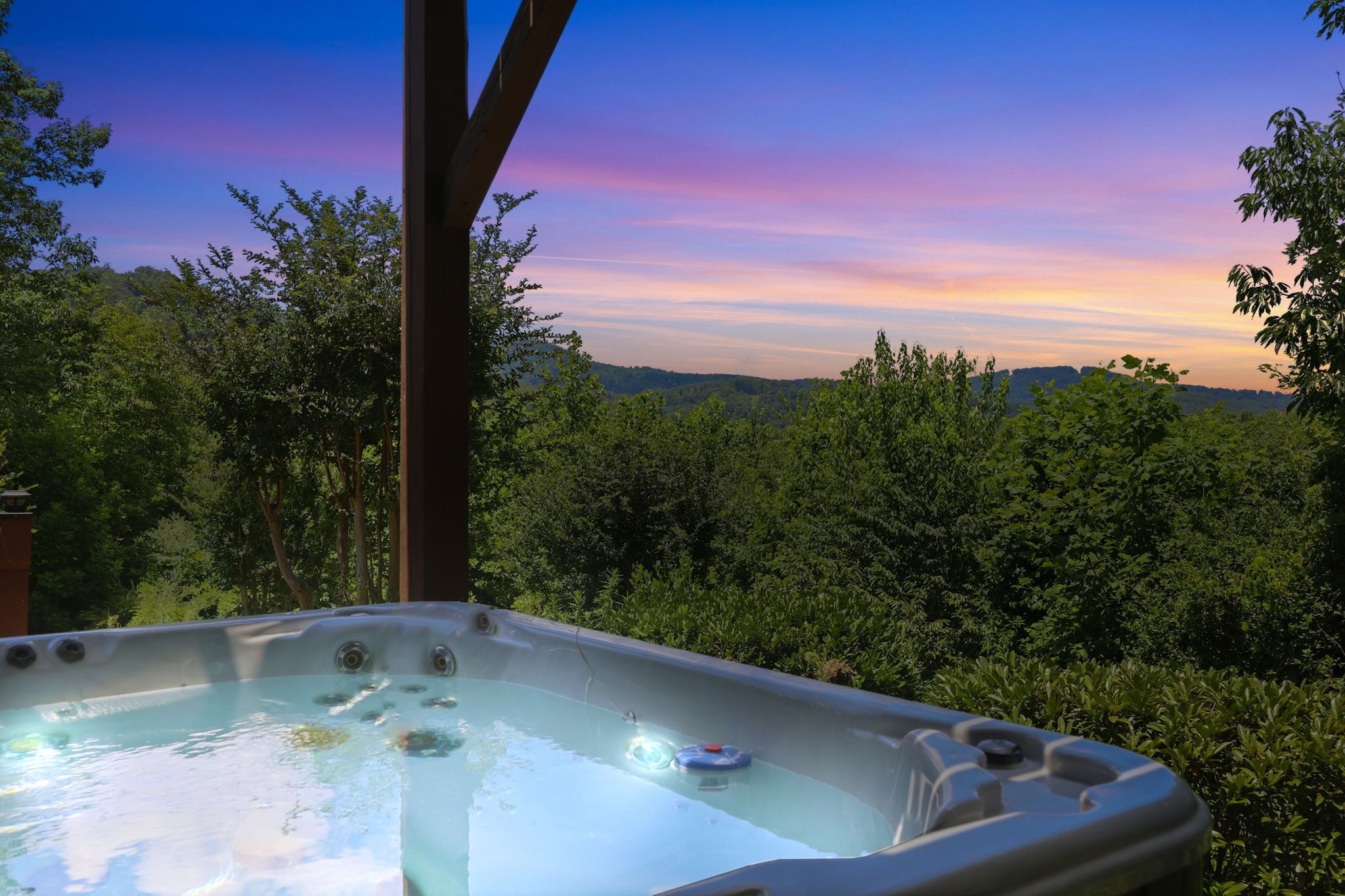 Ein Whirlpool mit Blick auf einen Wald und Berge.