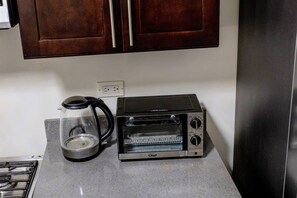 Eine Küche mit Kaffeemaschine, Toasterofen und Holzschränken.