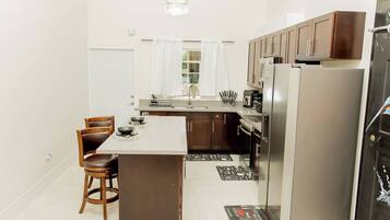 A modern kitchen with a central island, stainless steel appliances, and wooden cabinetry.