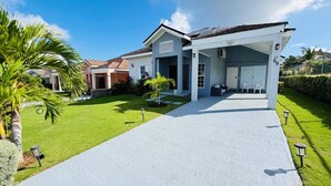 A modern two-story house with a covered driveway and a well-maintained lawn. - Beyond Escape-2br-gated-15 Min to Ocho Rios (Boscobel)