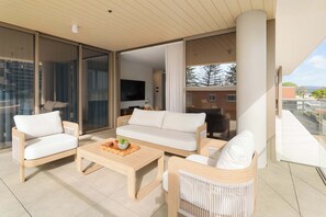 A modern living room with a sofa, chairs, a coffee table, and a TV. - Mahlo by Khove (Burleigh Heads)