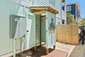 A small, enclosed outdoor area with a wooden deck, a metal utility box, and a wooden fence. - Luxury Ocean View Home w Pool Access, Rooftop, and Pool Table! (Carolina Beach)