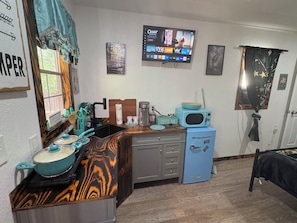 A compact kitchen with a microwave, coffee maker, and a sink.