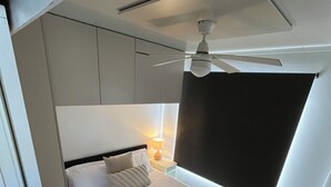 A modern bedroom with a bed, a ceiling fan, a nightstand, and a window with a view. - 3-bedroom house boat in beautiful Swan Reach with beautiful Murray River views. (Punyelroo)