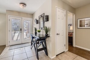 A hallway with a dining area, white doors, and a ceiling light fixture. - Spacious Family Home, 10 Min to Strip (Las Vegas)