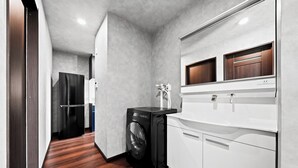 A compact kitchen with a washing machine, a built-in oven, and a microwave.