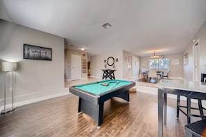 A spacious room with a pool table, a dining area with chairs, and a hallway leading to another room. - Family-Friendly Vegas Home, 10 Min to the Strip (Las Vegas)