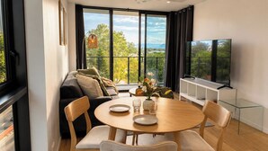 Una sala de estar moderna con sofá, mesa de comedor, sillas y televisor.