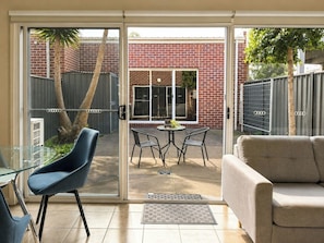 A modern living room with a glass door leading to a patio area.