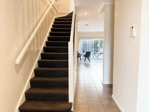 A staircase leading to a balcony with a view of the outside.