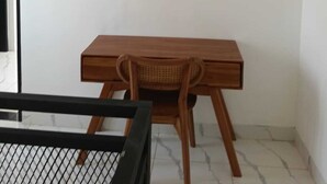 A room with a wooden desk, a wicker chair, and a black-framed bed. - Cozzy Villa Sakangi Mas (Tabanan)