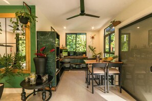Une cuisine moderne avec un coin repas, un ventilateur de plafond et diverses plantes.
