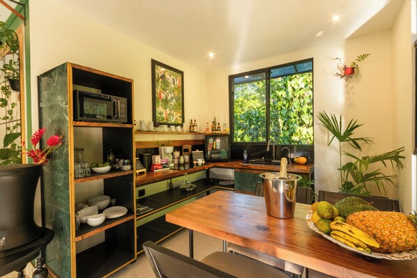 Une cuisine moderne avec une table en bois, un four à micro-ondes et divers appareils de cuisine.