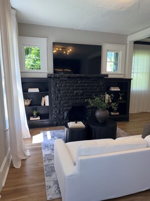 A living room with a fireplace, a sofa, and a bookshelf. -     Fully Remodeled 3Bed- 2 Bath  Home  Ideal for Extended Stays (Kansas City)