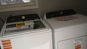 Twee voorladers van Whirlpool met instructieborden en een raam erboven.