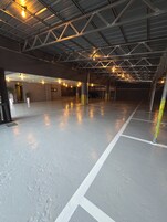 Amplio estacionamiento interior con techo alto y vigas metálicas.