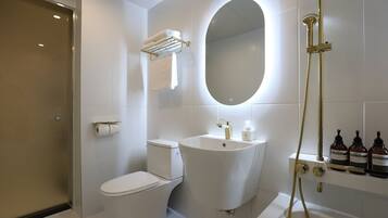 A modern bathroom with a toilet, sink, and shower.