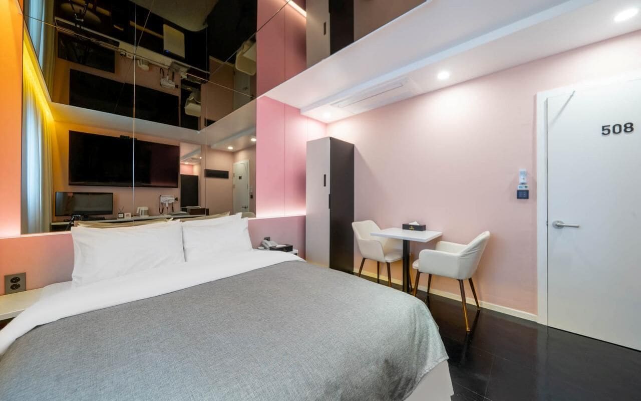Una moderna camera d'albergo con un letto, una scrivania e una sedia.