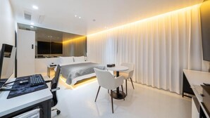 A modern hotel room with a bed, desk, chair, and a television. - Lizena HOTEL (Asan)