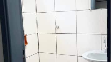 Chuveiro, toalhas de banho, sabonete, shampoo