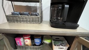 A kitchenette with a coffee maker, a wicker basket with cups, and storage containers. - Convenient Central Ky home in Georgetown, 11 mins to Horse Park (Georgetown)