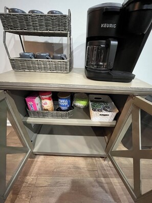 A kitchenette with a coffee maker, a wicker basket with cups, and storage containers. - Convenient Central Ky home in Georgetown, 11 mins to Horse Park (Georgetown)