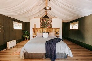 Camera da letto con un letto grande, una testiera in legno e un lampadario.