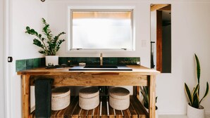 Una cocina con mostrador de madera, una ventana y una planta en maceta.